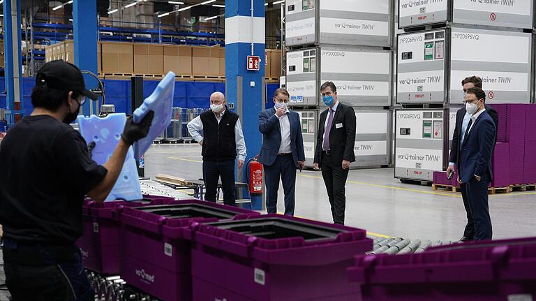 Oberbürgermeister Christian Schuchardt (Dritter von rechts) zusammen mit va-Q-tec-Chef Joachim Kuhn beim Rundgang durch die Halle des Würzburger Unternehmens.