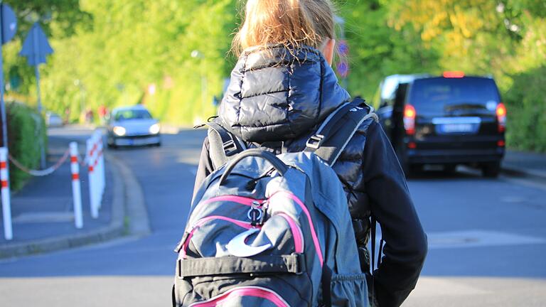 Gefahr für den Schulweg: Rechts im Bild hält ein 'Elterntaxi' bei einer Grundschule in Bad Kissingen im absoluten Halteverbot,   um Kinder aussteigen zu lassen.