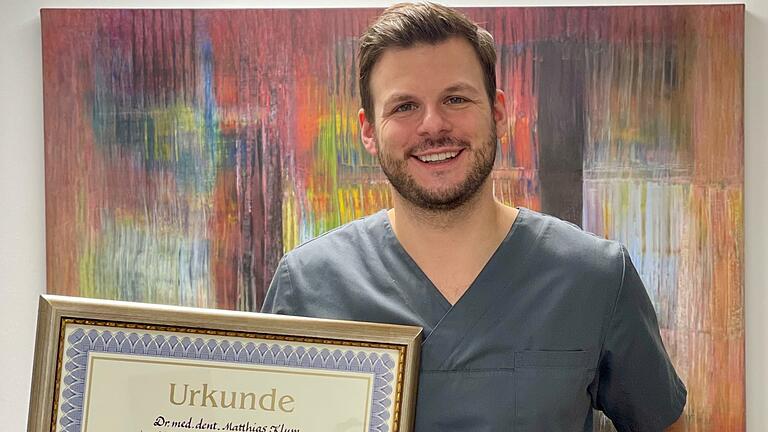 Dr. Matthias Klum zeigt stolz seinen 'Meisterbrief' und den 1. Preis für die beste Masterthese.