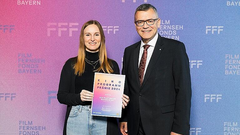 Anne Schmeltzer (Theaterleitung KuK Filmtheater) bekommt von Florian Herrmann (Staatsminister für Medien, Leiter der Bayerischen Staatskanzlei) den Preis überreicht. Anne Schmeltzer (Theaterleitung KuK Filmtheater) bekommt von Florian Herrmann (Staatsminister für Medien, Leiter der Bayerischen Staatskanzlei) den Preis überreicht.