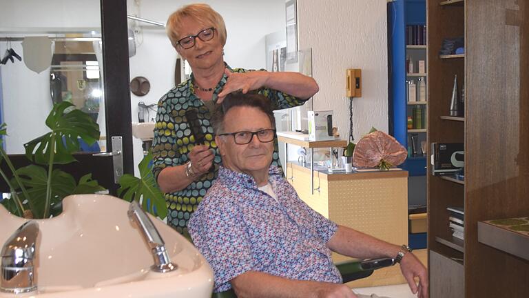 Friseurmeisterin Senorita Hensel hat für das Foto kurzerhand ihren Mann Bernd auf den Bedienstuhl im Herrensalon gesetzt. Seit 50 Jahren schneidet sie im eigenen Geschäft die Haare.