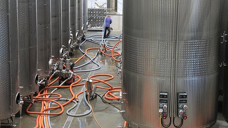 Ein bisschen Handarbeit ist auch noch: Ein Mitarbeiter schleppt ein paar Schläuche durch die Gassen der Gärtanks. Ein bisschen Handarbeit ist auch noch: Ein Mitarbeiter schleppt ein paar Schläuche durch die Gassen der Gärtanks.