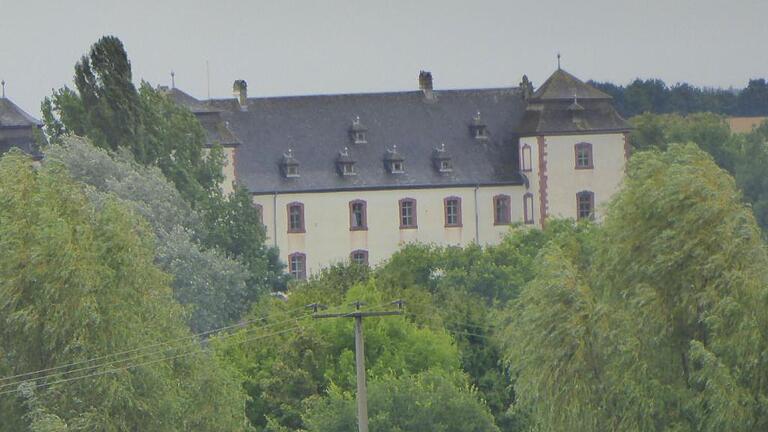 Schloss Walkershofen versteckt sich am Rand der Ortschaft hinter hohen Bäumen.