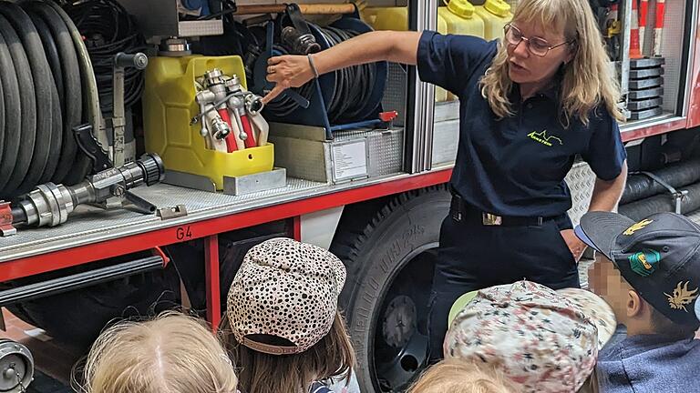 Gruppenführerin Mechthild Schepper erklärt den interessierten Kindern die im Einsatz mitgeführte Ausrüstung an den Fahrzeugen.