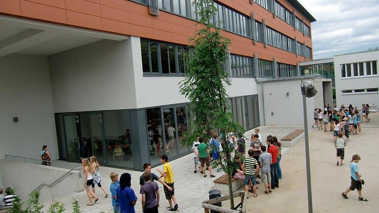 Das Armin-Knab-Gymnasium (AKG) in Kitzingen: Blick in den Schulhof mit Schülerinnen und Schülern.