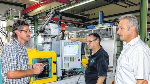 Fertigung der Kunststoffkäfige: Der hochtemperaturbeständige Kunststoff Polyetheretherketon (PEEK) wird unter hohem Druck geformt. An einer der Fertigungsmaschinen (von links) Produktionsleiter Tiemo Stürzenberger, Schichtführer Herbert Ries und Geschäftsführer Werner Beuerlein. Fertigung der Kunststoffkäfige: Der hochtemperaturbeständige Kunststoff Polyetheretherketon (PEEK) wird unter hohem Druck geformt. An einer der Fertigungsmaschinen (von links) Produktionsleiter Tiemo Stürzenberger, Schichtführer Herbert Ries und Geschäftsführer Werner Beuerlein.