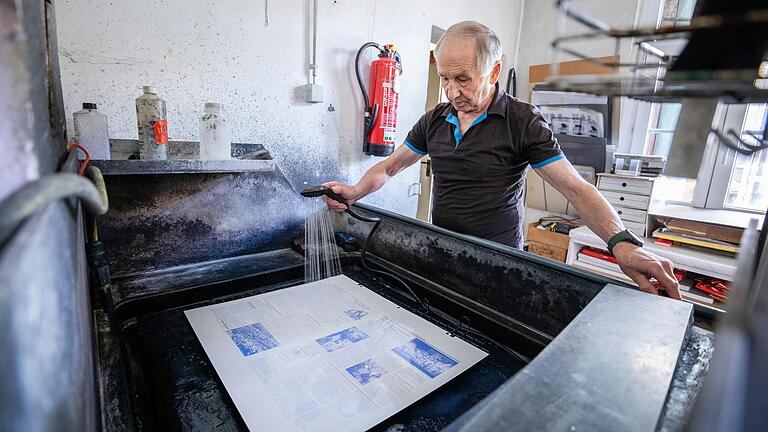 Volker Gunzenheimer duscht die fertige Druckplatte mit Leitungswasser ab.