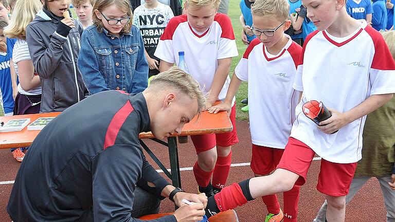 Nachwuchskeeper Lukas Wenzel gab beim Grundschulturnier Autogramme. Hier signiert er die Fußballschuhe des Mellrichstädter Spielers Luca Then.