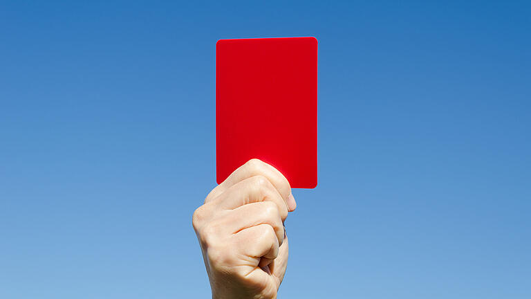 Red card in the hand against blue sky       -  Symbolbild: Rote Karte