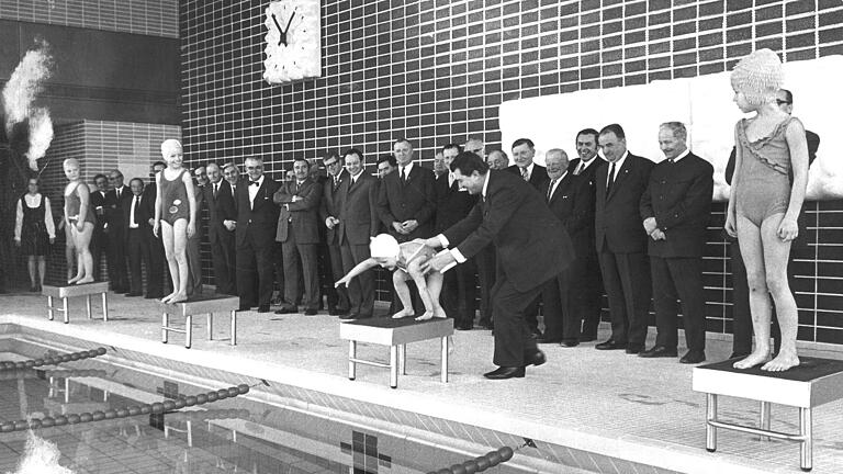 Eröffnung des neuen Hallenbads in Karlstadt am 26. Februar 1971: Landrat Erwin Ammann hilft der vierjährigen Petra Boxall auf den Startblock. Wer die anderen Schwimmerinnen sind, ist unbekannt.