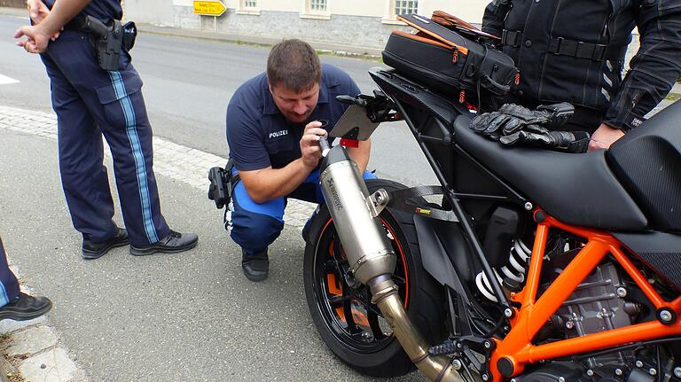 Mit einem Blick in den Auspuff eines Motorrades kontrolliert Thomas Kordmann das Innenleben des Zweirads. Wurde da etwas verändert? Mit einem Blick in den Auspuff eines Motorrades kontrolliert Thomas Kordmann das Innenleben des Zweirads. Wurde da etwas verändert?