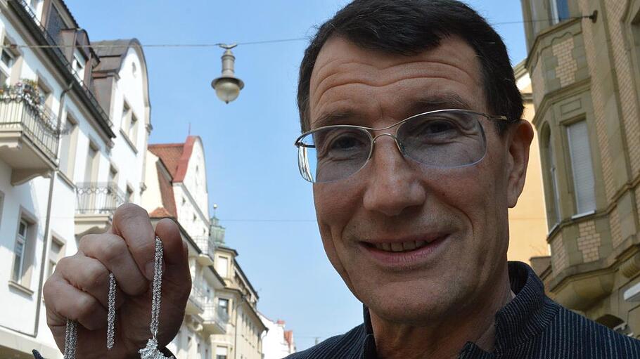 Malte Meinck zeigt den Schmuck, den er im Rahmen der Standortkampagne des Landkreises Bad Kissingen entwarf. Foto: Isolde Krapf       -  Malte Meinck zeigt den Schmuck, den er im Rahmen der Standortkampagne des Landkreises Bad Kissingen entwarf. Foto: Isolde Krapf