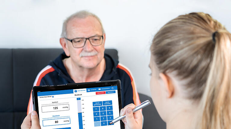 Eine Medizinische Fachangestellte überträgt die Vitalparameter in die Mia-App.       -  Eine Medizinische Fachangestellte überträgt die Vitalparameter in die Mia-App.
