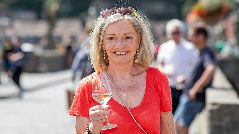 Elisabeth Klier aus Kulmbach (Oberfranken) gönnt sich mit ihrem Mann eine kleine Verschnaufpause auf der Alten Mainbrücke in Würzburg.