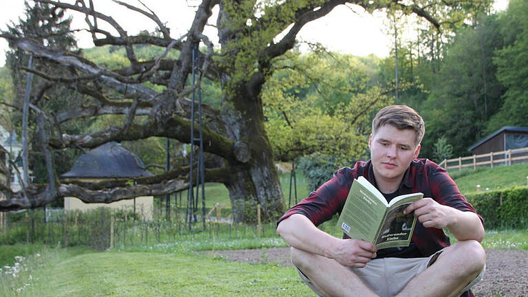 Lektüre am historischen Ort: Jonathan Kirchner an der König-Ludwig-Eiche im Staatsbad Brückenau. Foto: Ulrike Müller       -  Lektüre am historischen Ort: Jonathan Kirchner an der König-Ludwig-Eiche im Staatsbad Brückenau. Foto: Ulrike Müller