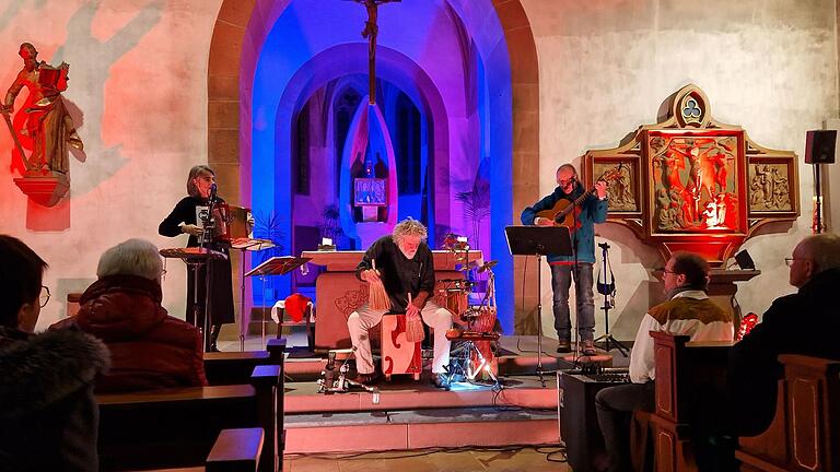 Der Liedermacher Jonathan Böttcher (Gesang, Gitarre) mit Bruno Bischler (Percussion) und Tatjana Breitenstein (Gesang, Glockenspiel, Akkordeon) (von rechts) verzauberte die zahlreichen Besucher*innen bei den 'Abendgesängen' des Pastoralen Raums Gemünden mit einfühlsamen und begeisternden Songs zum Mitsingen.