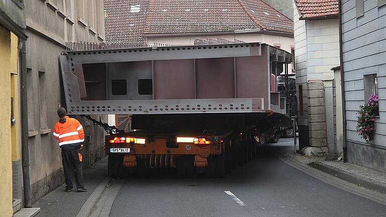 Im Karlstadter Ortsteil Mühlbach (Lkr. Main-Spessart) steckte der Schwertransport mit Stahlteilen der neuen Gemündener Mainbrücke erst einmal fest. Im Karlstadter Ortsteil Mühlbach (Lkr. Main-Spessart) steckte der Schwertransport mit Stahlteilen der neuen Gemündener Mainbrücke erst einmal fest.