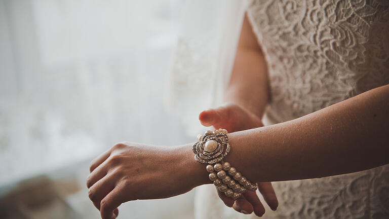 Bracelet from pearls on a hand 2309.       -  Ob als Armband, Kette oder im Brautstrauß, früher bedeuteten Perlen auf einer Hochzeit, Unglück in der Ehe.