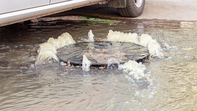 Überschwemmung nach Starkregen       -  Das Regenwasser drückt aus der Kanalisation, weil es nicht abfließen kann.