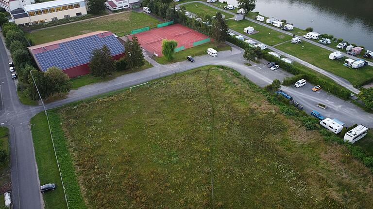 Vom Freibad (nicht im Bild) über das Sportgelände des TV Zellingen (mit Tennisplätzen und Halle) und den Campingplatz am Main bis zur Friedrich-Günther-Halle gilt nun der Bebauungsplan 'Sondergebiet Freizeitgelände'. Aufgestellt wurde er, um den Campingplatz auf den brach liegenden ehemaligen Bolzplatz erweitern zu können. Die Stellplätze links des Bolzplatzes werden mit PV-Modulen überdacht.