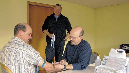 Dr. Tim Weisensee (rechts), der Feuerwehrarzt der Gemeinde Hausen, führte zum Abschluss der Hepatitis-B-Impfaktion eine Titerbestimmung bei den aktiven Feuerwehrlern durch. Er wurde von Axel Jung (Mitte) unterstützt. Mit der Blutlaboruntersuchung kann der Impfstatus ermittelt und der Erfolg der Grundimmunisierung überprüft werden.