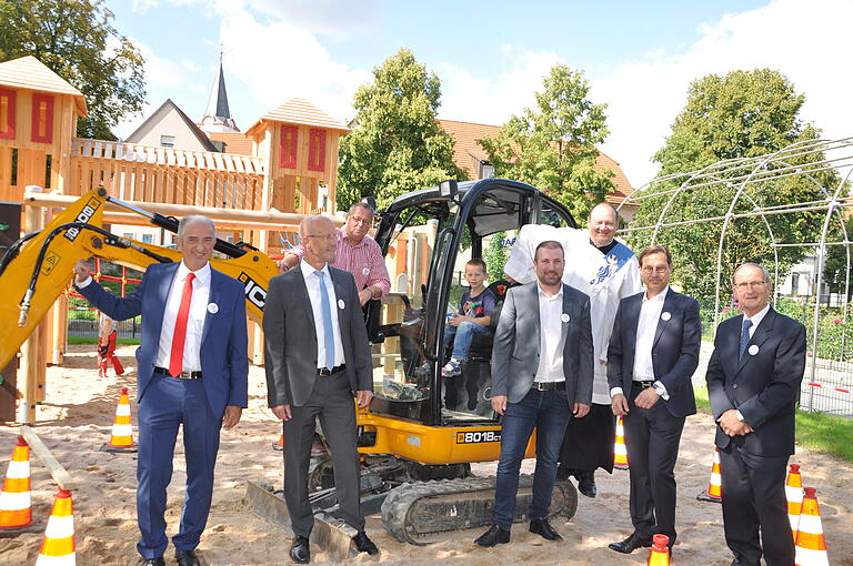 Im Bild die Ehrengäste vor dem von den Kindern gut angenommenen Bagger von links Roberto Nernosi, Frank Klose, 2. Bürgermeister Jürgen Geist, Bürgermeister Stefan Rottmann, Diakon Frank Menig, Frank Hefner und Lektor Gerhard Räth.