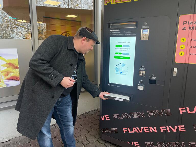 Nach vier Minuten kommt der Karton mit der fertigen Pizza aus dem Automaten. Nach vier Minuten kommt der Karton mit der fertigen Pizza aus dem Automaten.
