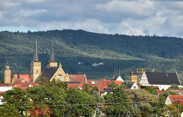 Die Höhenzüge des Steigerwald (Foto von August 2023) sind frei von Windrädern. Die umfangreichen Natur- und Artenschutzflächen dort, stehen dem Bau von Windkraftanlagen entgegen. Im Bildvordergrund ist die Stadtsilhouette von Gerolzhofen zu sehen, dahinter, im Wald, die Waldesruh.