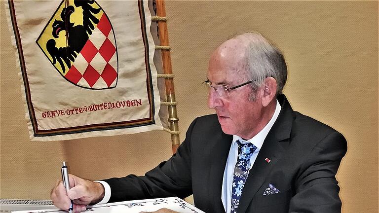 Werner Vogel trägt sich als neuer Ehrenvorsitzender ins Goldene Buch des Reiterswiesener Heimatvereins ein. Foto: Sigismund von Dobschütz       -  Werner Vogel trägt sich als neuer Ehrenvorsitzender ins Goldene Buch des Reiterswiesener Heimatvereins ein. Foto: Sigismund von Dobschütz