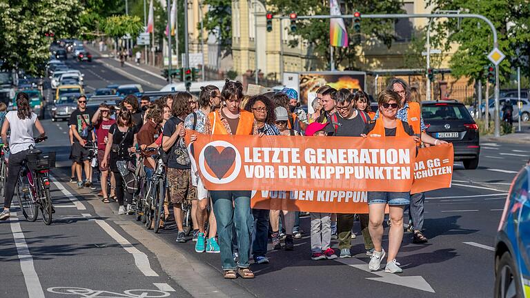 Rund 50 Menschen der Gruppe 'Letzte Generation' nahmen am Mittwoch an einem Protestmarsch vom Röntgenring über die Friedensbrücke in Würzburg teil.