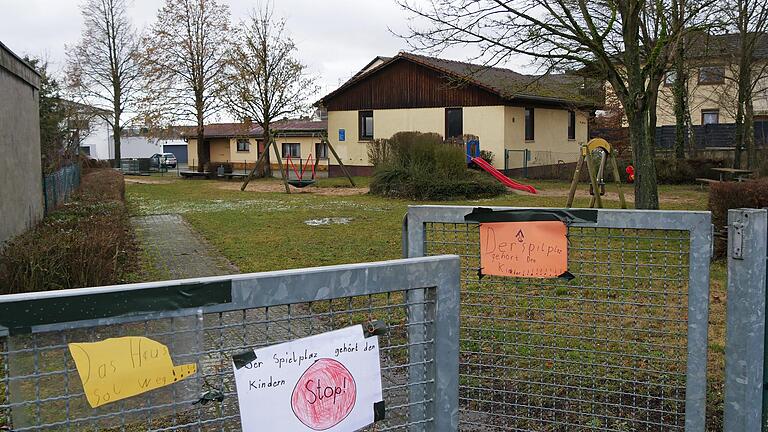 Die geplante Nachnutzung des früheren Feuerwehrhauses in Unterpleichfeld (im Hintergrund) stößt auf Widerstand. Am Zaun des angrenzenden Spielplatzes wurden Kinderzeichnungen aufgehängt.