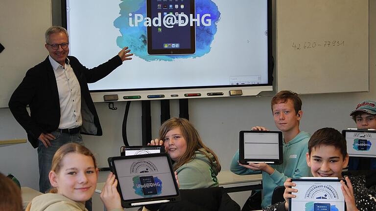 Schülerinnen und Schüler einer 7. Klasse des Deutschhaus-Gymnasiums zeigen stolz ihre neuen i-Pads. An der Tafel der Schulleiter des DHG, OStD Michael Schmitt. Schülerinnen und Schüler einer 7. Klasse des Deutschhaus-Gymnasiums zeigen stolz ihre neuen i-Pads. An der Tafel der Schulleiter des DHG, OStD Michael Schmitt.