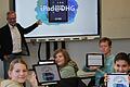 Schülerinnen und Schüler einer 7. Klasse des Deutschhaus-Gymnasiums zeigen stolz ihre neuen i-Pads. An der Tafel der Schulleiter des DHG,  OStD Michael Schmitt.
