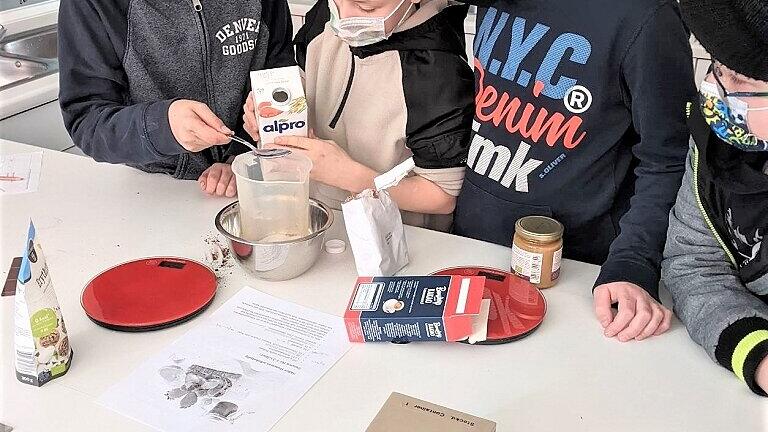 Max Vogl, Jim Chlupka, Simon Ewald und Luca Lange stellen in der Schulküche Schoko-Hummus her.