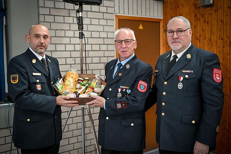 Kreisbrandrat Florian List (links) und Kreisbrandinspektor Andreas Schmitt (rechts) verabschieden&nbsp; Kreisbrandmeister a. D. Thomas Baumann in den Feuerwehr-Ruhestand.