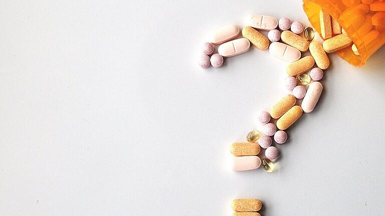 different drugs and health supplement pills in a question mark p       -  _