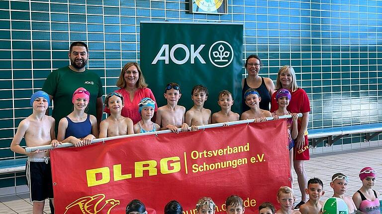 Schülerinnen und Schüler der Grundschule Schonungen sind stolz auf ihr Schwimmabzeichen. Hinten von links:Aliemre Toprak, Teamleiter der Öffentlichkeitsarbeit in der AOK Schweinfurt; Jana Niedermeyer, Rektorin GS Schonungen; Kathrin Wagenhäuser, Schwimmlehrkraft; Carolin Reuter, DLRG-Schwimmtrainerin.