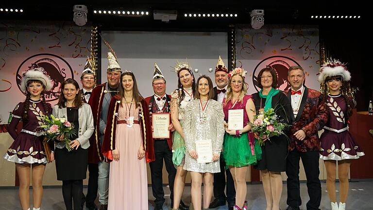 Eingerahmt von zwei Gardemädchen freuen sich die Geehrten und ihre Gratulanten (von links): Landrätin Sabine Sitter, OCV-Präsident Thomas Fuhrmann, Prinz Simon I., Prinzessin Katharina II., Siegfried Schwab (neuer Träger des Tills von Franken), Lisa Singer, Kira Heim und Carina Stahl (alle drei mit Verdienstorden), Siggi Schnellbach vom Fastnachtsverband Franken, Bürgermeisterin Agnes Engelhardt und Landtagsabgeordneter Thorsten Schwab.