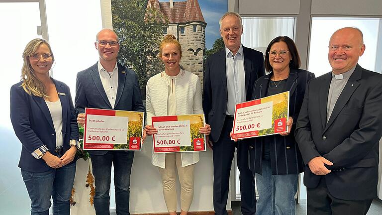 Julia Martin (Leiterin Beratungscenter), Bürgermeister Dieter Lenzer, Dominice Weiglein (Abteilung Judo FC Iphofen), Sparkassen-Vorstandsvorsitzender Bernd Fröhlich, Kindergartenleiterin Marion Beringer und Pater Adam Was bei der symbolischen Scheckübergabe.