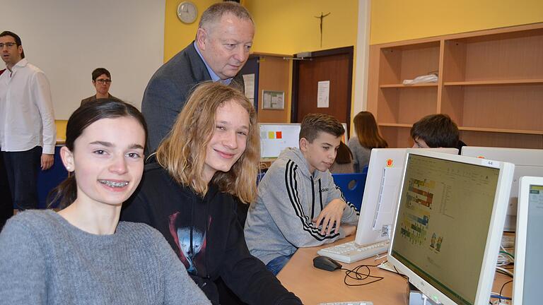 Im Informatik-Unterricht am Hammelburger Frobenius-Gymnasium sollen die Schülerinnen und Schüler Spiele am Computer programmieren. Hannah Eckert und Joshua Sell (vorn) zeigen, was sie an kreativen Ideen drauf haben. Im Bild mit Landrat Thomas Bold.