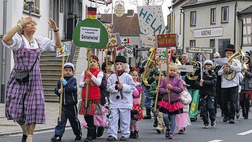 Maria Hellwig singt in Narrenwind       -  (ast)   Wenn aus Geiselwind &bdquo;Narrenwind&ldquo; wird, dann ist auch im Steigerwald der Fasching am Höhepunkt angekommen. Ein kleiner Zug schlängelte sich am Dienstagnachmittag vom Ortseingang zum Marktplatz. Viele maskierte Kinder zogen zu den Klängen der Steigerwaldkapelle zur Ortsmitte. Ganz vorne im feschen Dirndl steckte Gaudimax Stefan Rückel, der später auf dem Platz als &bdquo;Volksmusik-Sängerin Maria Hellwig&ldquo; eine Kostprobe gab. Zu &bdquo;Servus, Gruezi und Hallo&ldquo; wurde gejodelt und getanzt, was die Besucher am Marktplatz zu Schunkelrunden animierte. Die Steigerwaldkapelle unter der Leitung von Toni Müller spielte einige Stücke, schließlich ging es für den Zug zum Kinderfasching in den Gasthof Krone. Dort sorgte ein Discjockey für die Musik, bei der sich die kleinen Mäuse, Schlümpfe, Polizisten, Piraten und Zauberer noch einmal austoben konnten.