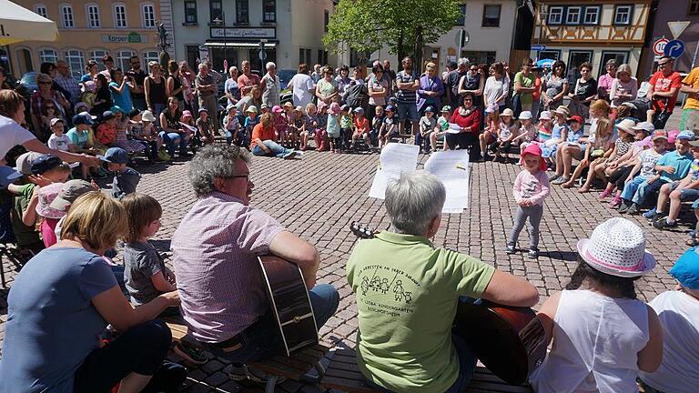 Kindergartenkinder lassen den Marktplatz erklingen       -  (mec)   Der Marktplatz von Bischofsheim war die Bühne für die Kindergartenkinder aus Bischofsheim am &bdquo;Aktionstag Musik&ldquo;. Voller Begeisterung sangen sie für die vielen Gäste und zeigten, wie viel Freude sie am Gesang haben. Seit einigen Jahren ist der St. Lioba Kindergarten am Aktionstag auf dem Marktplatz vertreten. In diesem Jahr lautete das bayernweite Motto &bdquo;Musik ist mein Zuhause&ldquo;, das von der bayerischen Landeskoordinierungsstelle Musik herausgegeben wurde. Zum Auftakt gab es das &bdquo;Kindergartenlied&ldquo;, in dem die Kinder von dem berichteten, was im Kindergarten so alles los ist. Der St. Lioba Kindergarten ist ein katholischer Kindergarten, da durfte dann auch ein Marien-Lied nicht fehlen. &bdquo;Der Mai grüßt Maria, die Mutter des Herrn&ldquo;, sangen die Kinder, während viele Eltern und Großeltern eifrig filmten und fotografierten. Für die musikalische Begleitung sorgten Klaus Kirchner und Ingrid Fries. Im Anschluss an den Auftritt auf dem Marktplatz ging es zum Picknick in den Garten des Kardinal-Döpfner-Hauses.