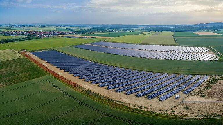 Mitten rein in die Landschaft: Solarparks wie hier in Herlheim (Lkr. Schweinfurt) sind Teil der Energiewende in Deutschland. Doch die glänzenden Module für Sonnenstrom sind mitunter Stein des Anstoßes in der Bevölkerung geworden.