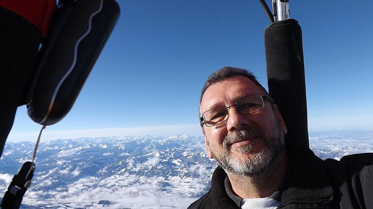 Elmar Fietz, Vorsitzender des Freiballonclub Franken e.V. Schweinfurt bei einer Ballonfahrt mit Blick auf die Alpen.