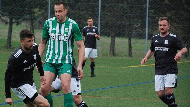 Daniel Leicht (links) vom FC Strahlungen (rechts Sebastian Braun) luchst Sebastian Heinlein (FC Untererthal) den Ball ab.