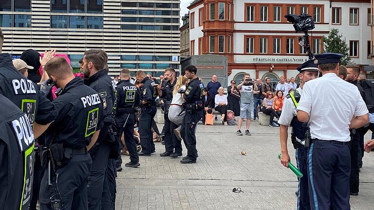 Ein Polizist trägt eine Teilnehmerin der Gegendemo weg.&nbsp;&nbsp;