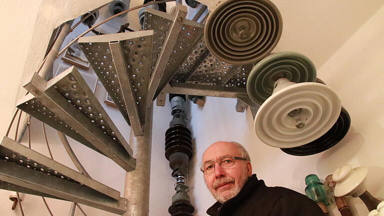 Lothar Vormwald in seinem Isolatorenmuseum. In den ersten Stock des Trafohäuschens aus dem Jahr 1919 führt eine schmale Wendeltreppe.