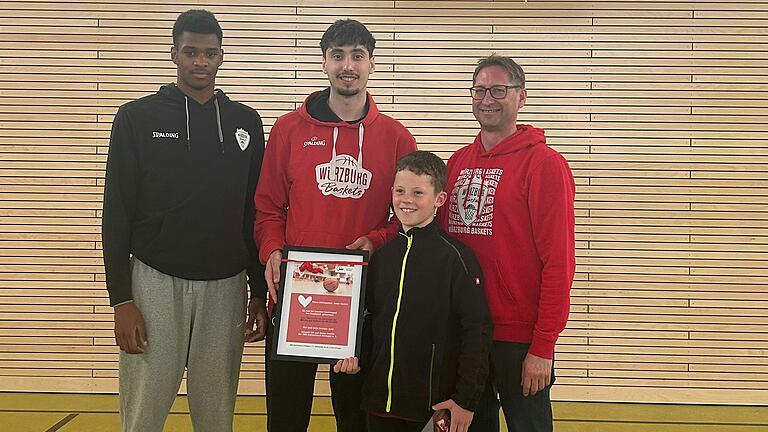 Elijah Ndi und Julius Böhmer von den Würzburger Baskets zusammen mit dem Gewinner Marlon Kess und dem Vorsitzenden des AWO Kreisverbandes Gerald Möhrlein bei der Preisübergabe.