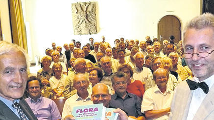 Vor großem Publikum in der Schweinfurter Rathausdiele hält Lenz Meierott (links) die &bdquo;Neue Flora&ldquo; erstmals in Händen, überreicht von Verleger Helmuth Schmid.