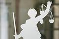 Die Figur der Justitia mit Richtschwert und Waage ist auf dem Glasfenster einer Tür im Gerichtsgebäude zu sehen. Die Göttin der Gerechtigkeit soll verdeutlichen, dass das Recht ohne Ansehen der Person und nach sorgfältigem Abwägen der Lage gesprochen und mit der notwendigen Härte durchgesetzt wird (Symbolbild).